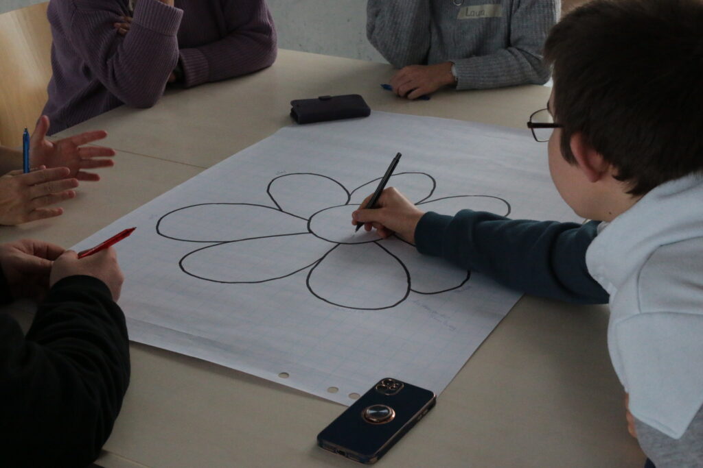 Eine angehende Bildungsfachkraft beschriftet in einer Lehrveranstaltung ein Flipchart.